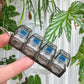 Clickie Keychain in hand, showcasing its stylish design with four transparent sections and blue accents.
