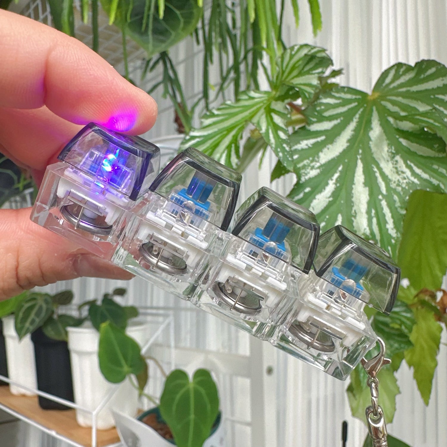 Clickie Keychain with LED lights, showcasing a hand holding the stylish key organizer.