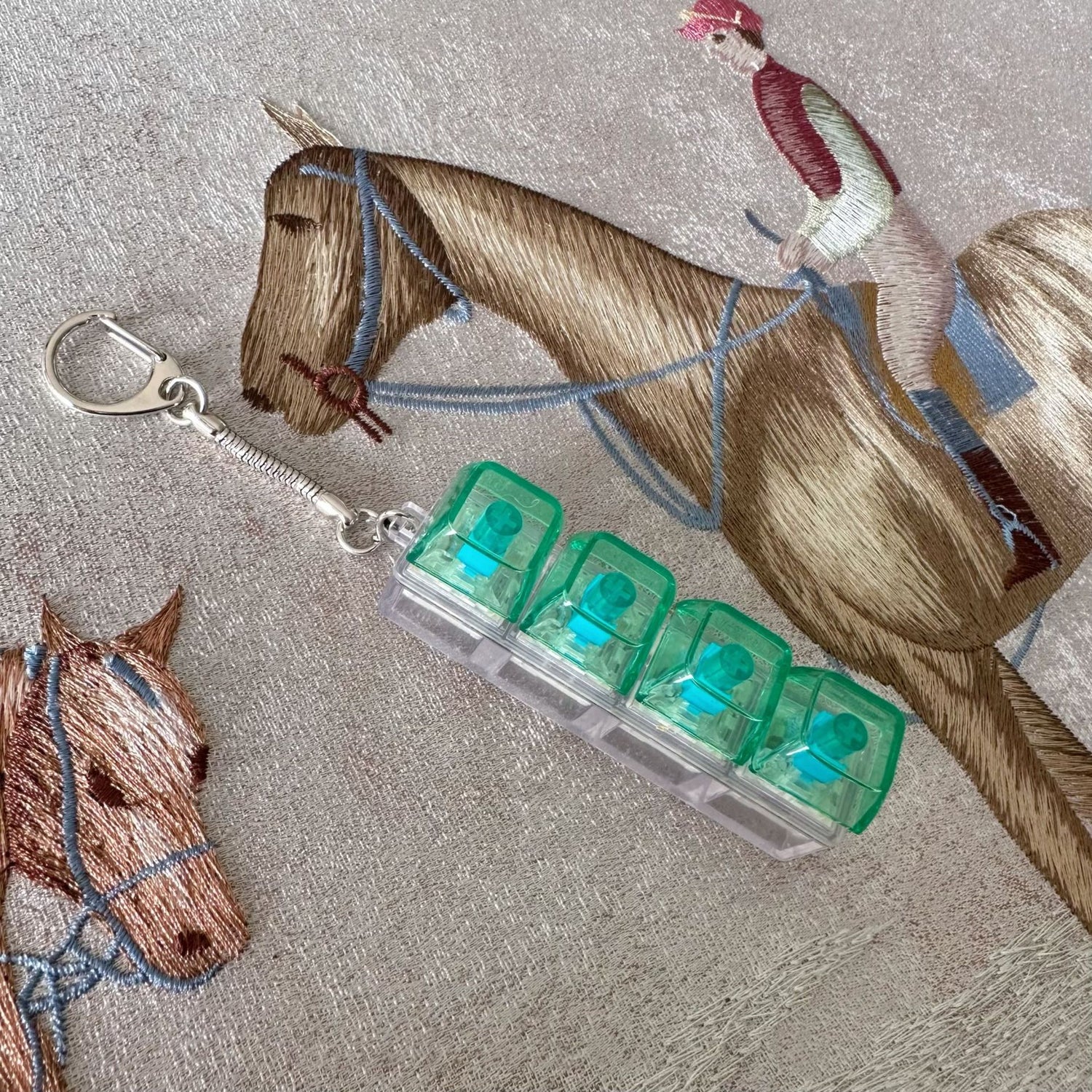 Clickie Keychain featuring transparent container with green lids for organizing keys and accessories.