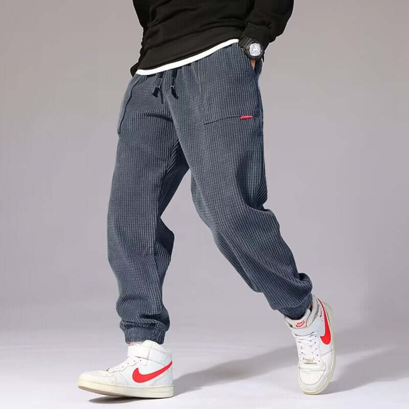 Mens Casual Pants in a relaxed fit, featuring pockets and styled with white sneakers.