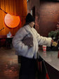 Woman wearing a Fluffy Fox Fur Coat Women Loose Elegant Winter at a café with a warm ambiance.