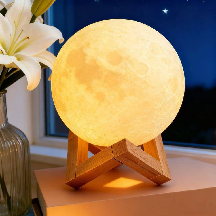 Rechargeable Moon Night Light with Touch Control on a wooden stand next to a flower vase, illuminating a cozy room.