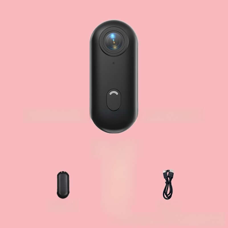 4K Thumb Camera – Ultra Compact in black with charging cable on a pink background.